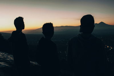 Silhouette people standing against sky during sunset