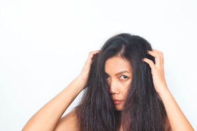 Portrait of young woman against white background