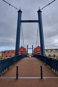 View of suspension bridge against cloudy sky