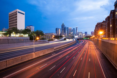 Light trails on road amidst buildings in city