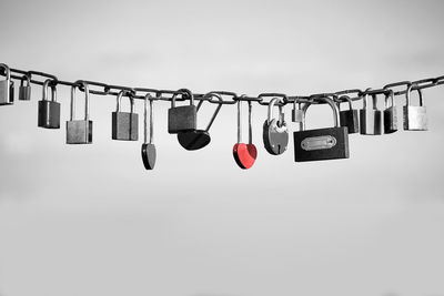 Close-up of padlocks hanging on metal against sky