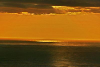 Scenic view of sea against orange sky