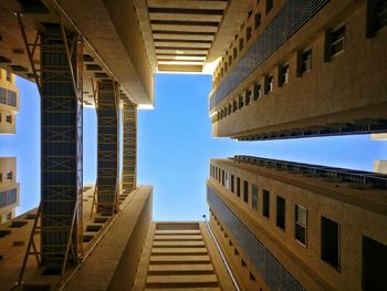 Low angle view of buildings against clear blue sky