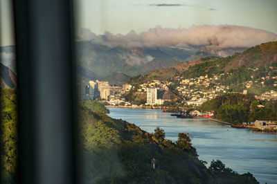 City by sea against sky seen through window