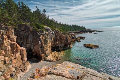 Rock formations by sea against sky