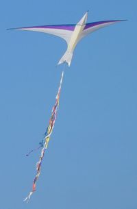 Low angle view of colorful kite flying against clear blue sky