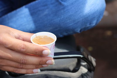 Close-up of hand holding coffee cup