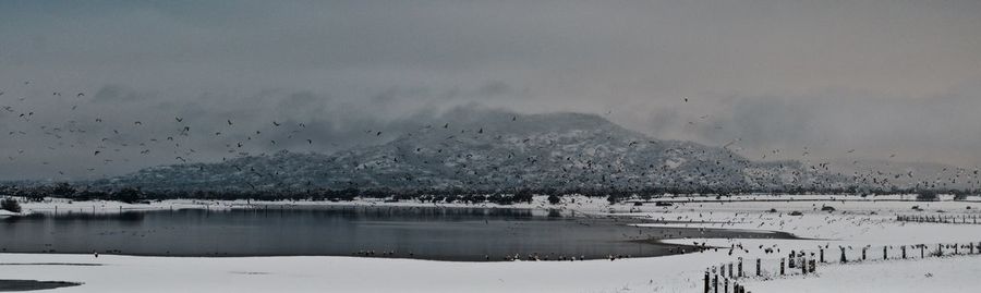 Scenic view of lake against sky during winter