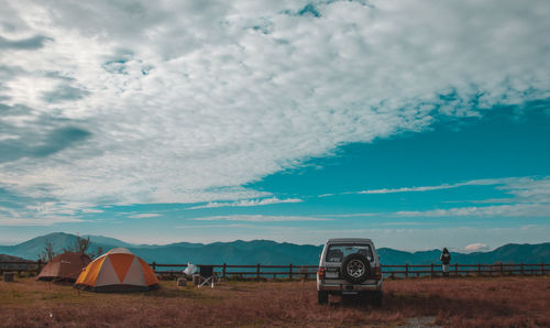 Tent on field by sea against sky