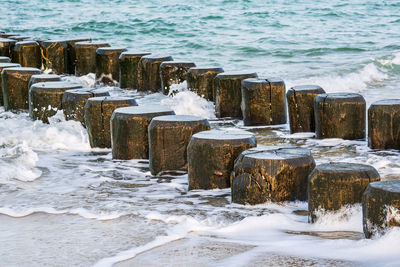 Wooden posts on beach during winter