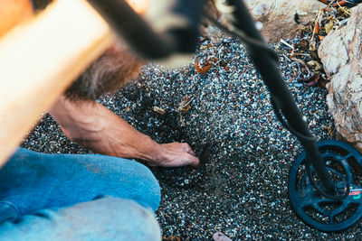 High angle view of man searching with metal detector on field