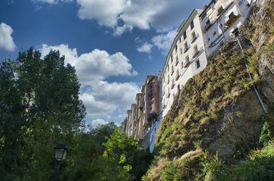 Low angle view of trees and buildings against sky