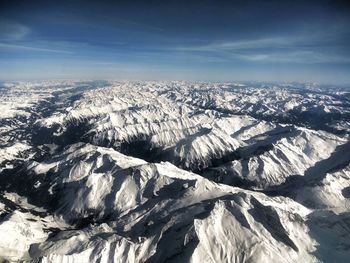 Aerial view of snowcapped mountains against sky