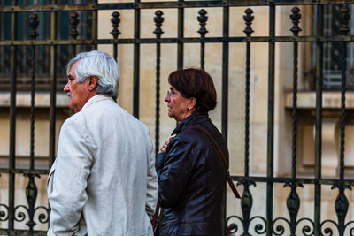 Rear view of men standing by railing