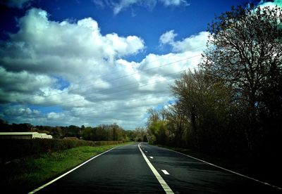 Empty road against cloudy sky