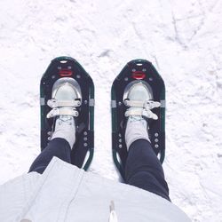 Low section of person wearing snowshoe on field