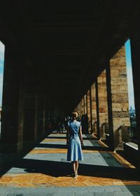 Rear view of woman standing in corridor