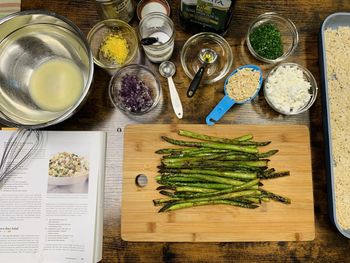 High angle view of food preparation with cookbook and food ingredients on table