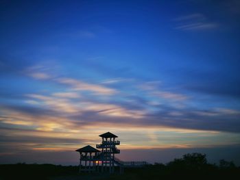 Silhouette building against sky at sunset