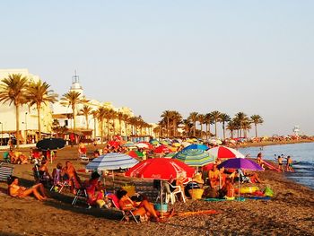 People at beach against clear sky