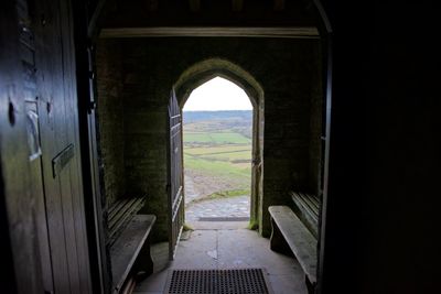 Landscape against sky seen through doorway of church