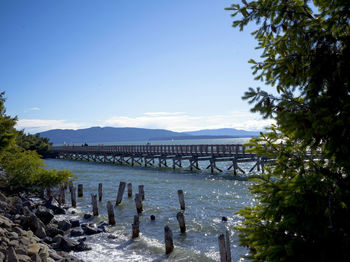 Bridge over river against clear blue sky