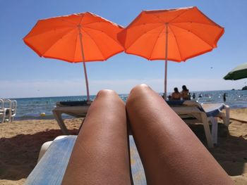 Low section of woman relaxing on beach