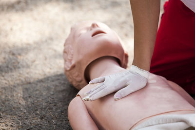 Midsection of paramedic performing cpr on dummy
