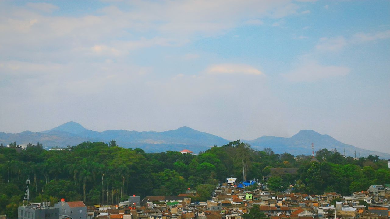 mountain, built structure, architecture, sky, building exterior, tree, mountain range, cloud - sky, scenics, house, high angle view, nature, landscape, tranquility, beauty in nature, day, tranquil scene, outdoors, town, roof