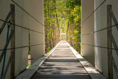 Rear view of man walking on footbridge