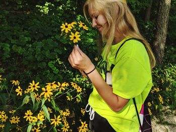 Low section of person holding yellow flowering plants