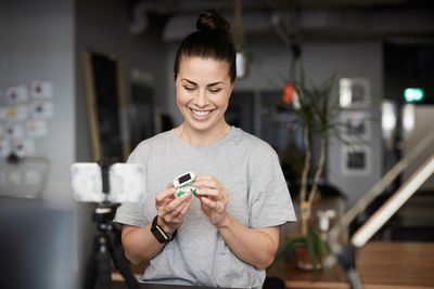 Female entrepreneur smiling while giving presentation on solar toy car through conference call in office