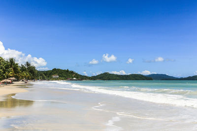 Scenic view of beach against blue sky