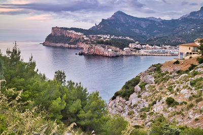 Scenic view of sea by mountains against sky