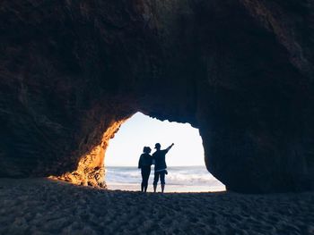 People standing on rock at beach