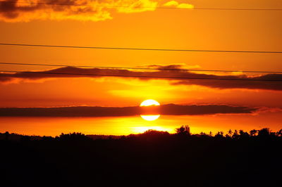 Scenic view of silhouette landscape against orange sky