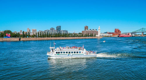 Boat sailing in river against blue sky