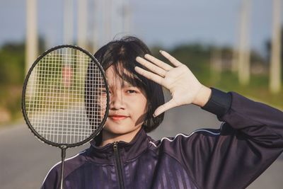 Portrait of teenager sport girl playing with badminton racket.