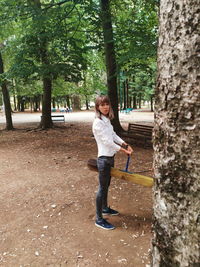 Full length portrait of girl standing by tree