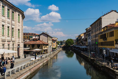 Canal amidst buildings in city against sky