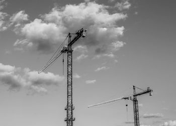 Low angle view of cranes against sky