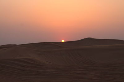 Scenic view of desert against sky during sunset