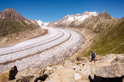 Rear view of backpacker walking on mountain