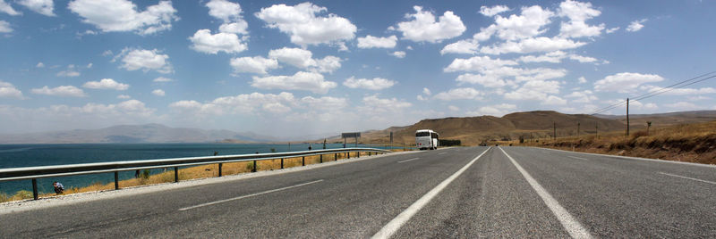 Road by mountains against sky