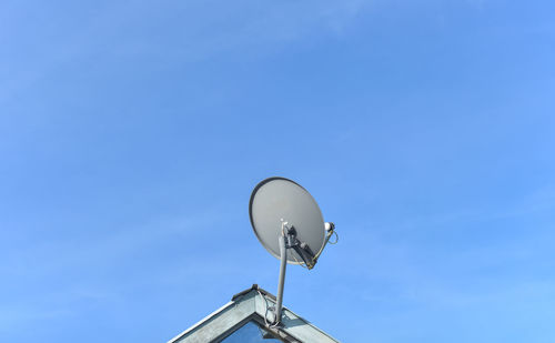 Low angle view of telephone pole against blue sky