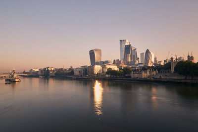 View of riverbank thames river against skyscrapers. urban skyline of london at morning light.