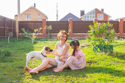 Woman with dog sitting on grass