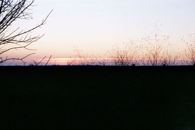 Silhouette landscape against clear sky at dusk