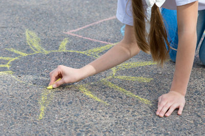 Woman drawing with chalk on road