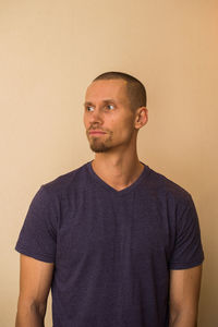 Portrait of mid adult man standing against wall